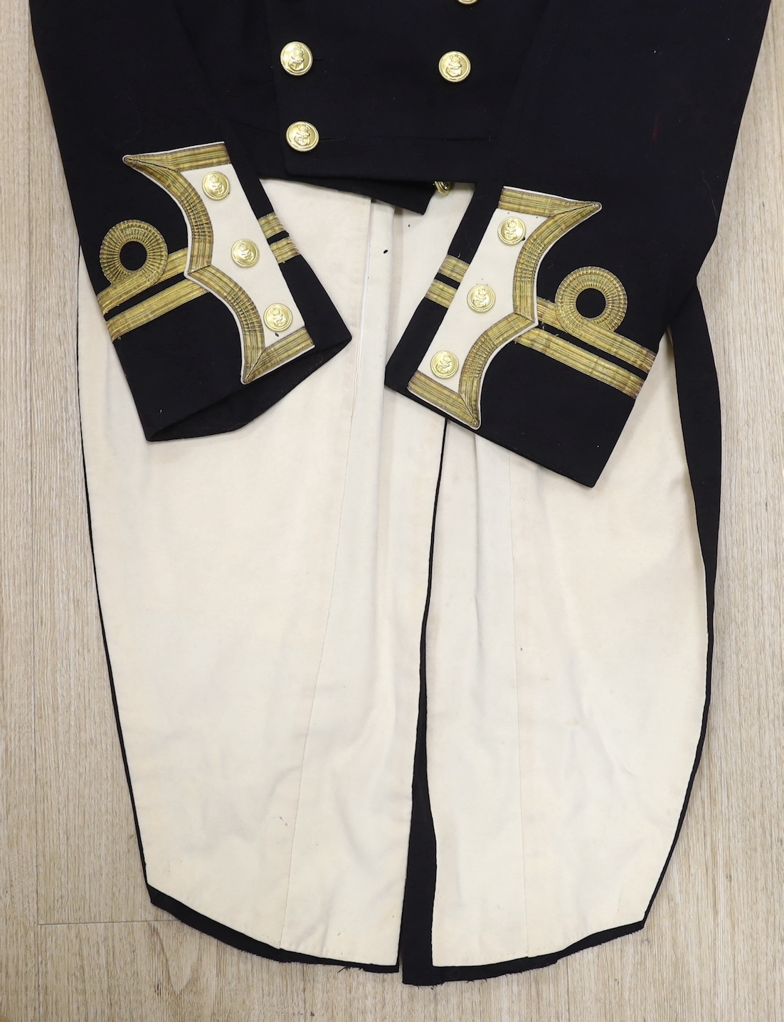 A 19th century gentleman's black wool Naval tail jacket with brass buttons gold